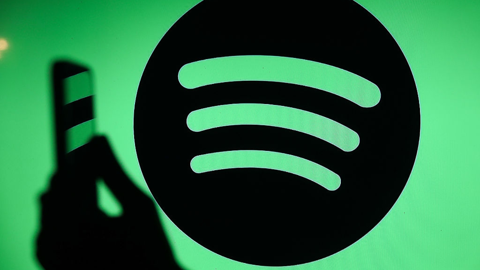 The Spotify logo displays on a screen with a person holding a phone in Knurow, Poland, on September 20, 2025. (Photo by Klaudia Radecka/NurPhoto via Getty Images)